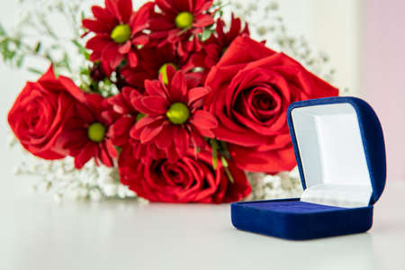 blue box for jewelry against the background of a bouquet of flowers. high qualityの写真素材