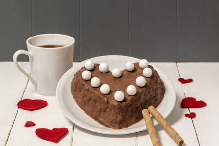 Chocolate cake in the shape of the heart on the tree background. concept for Valentine's Day. high...