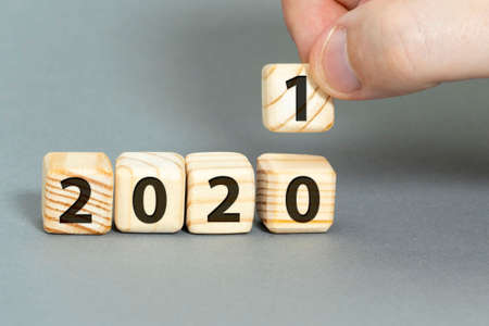 new year concept. wooden cubes 2020 hand replacement for 2021. high quality