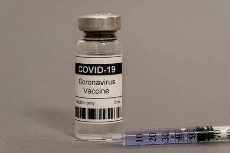 Concept. coronavirus vaccine and syringe on a gray background. high quality