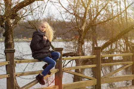 portrait of a teenage girl with blond hair in an early spring parkの写真素材