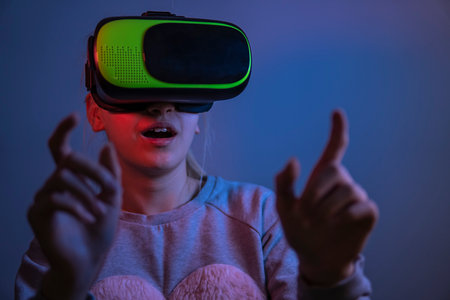 Teenage girl in virtual reality glasses in a dark room. selective focus.