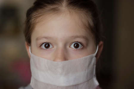 Little european girl wearing mask for protect pm2.5. Sick child Little girls look at the camera...
