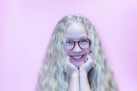 Beautiful caucasian teenager girl wearing white t-shirt over pink background showing and pointing up...