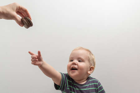 Cute little boy reaching for the chocolate chip cookiesの写真素材