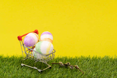 shopping basket with Easter eggs on a yellow background. willow on the grass. ... high qualityの写真素材
