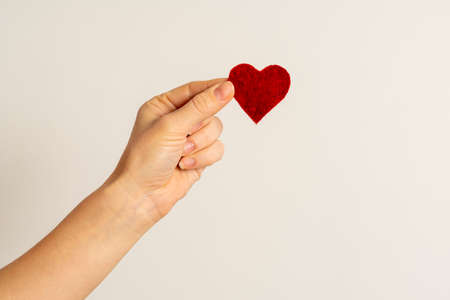 hand to hold the red heart. on a white background. concept birthday and Valentine's Day. high...