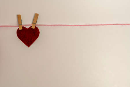 The red heart hangs on the clothespin. White background. A place for text. The concept of...