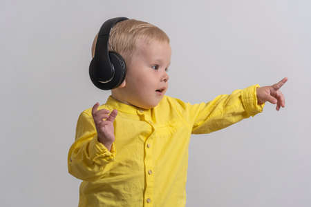 boy with blond hair in headphones show right.