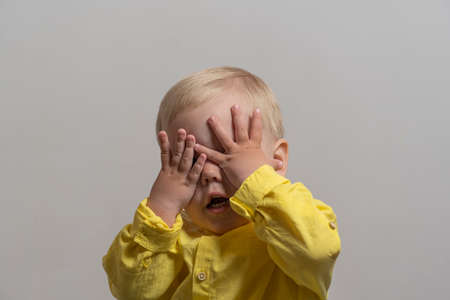boy with blond hair and yellow shirt close his eyes.の写真素材