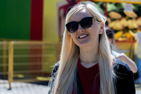 portrait of a woman in glasses with blonde hair on a sunny day.の写真素材