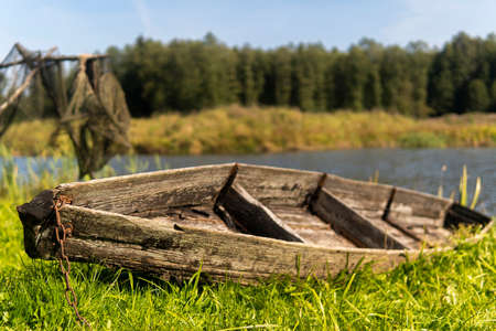 old wooden boat to the shore of the lake on a sunny dayの写真素材