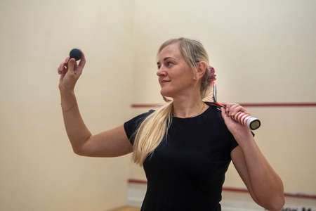 blonde girl holding a racket for squash games.の写真素材