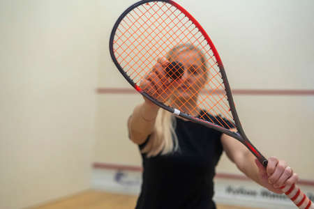 blonde girl holding a racket for squash games.の写真素材