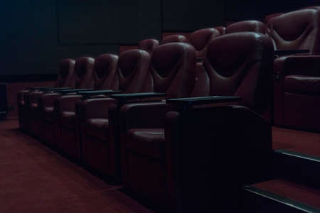 rows of brown leather armchairs in an empty cinema hall in a movie theater during coronavirus quarantine.の写真素材