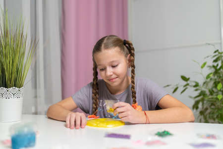 girl play with yellow slime at table fun at home.の写真素材
