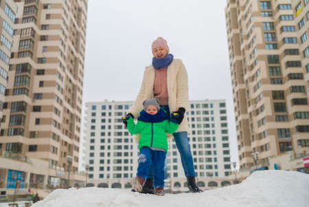 mother and son on a snow slide to the city.の写真素材