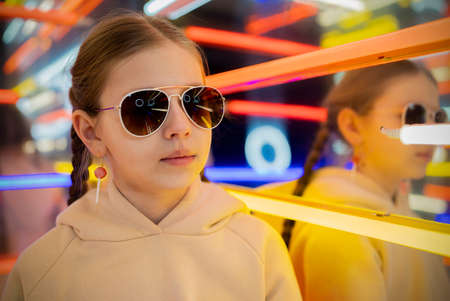 portrait of a stylish teenage girl in a neon roomの写真素材