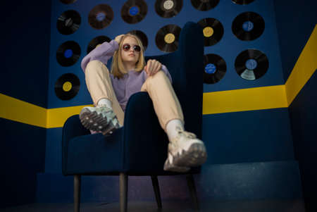 portrait of stylish teenage girl on a blue chair