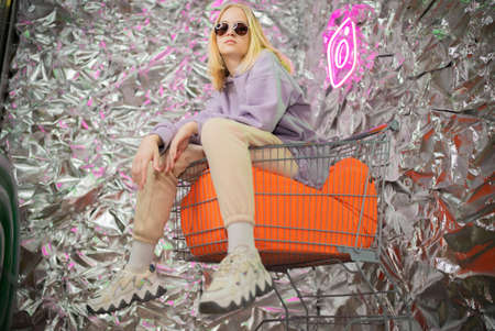 Portrait of a stylish blonde girl on a silver background.の写真素材