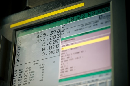 CNC machine monitor display with program code running and numbers with parameters changingの写真素材