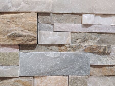 Marble wall background. Wall of colorful textured pieces of unpolished marble in light gray, beig and pink shades.の写真素材
