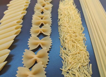 Pasta on dark background. Different types of dry italian pasta on a gray background.の写真素材