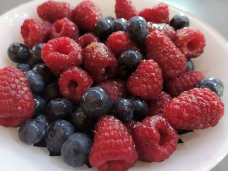 Raspberries and currants in a bowl. Dessert salad Macedonia of berries. Italian Cuisine.
