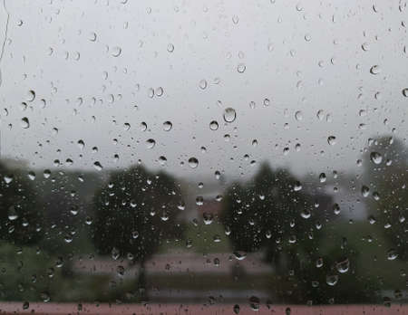 rain on the window on a gray background, rainy weather, wet. raindrops on the window, in the...