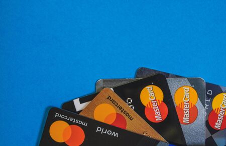 Several cards of the international payment system Mastercard on a blue surface. Saint Petersburg, Russia. February 03, 2020. The copy space. Horizontal orientation. View from above. Selective focus.のeditorial素材