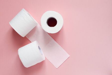 Lots of rolls of white toilet paper on a pink background. Panic, covid-19 concept. Horizontal...
