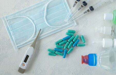 Objects to protect against covid-19 - medical mask, syringes and tablets, thermometer, antiseptics...