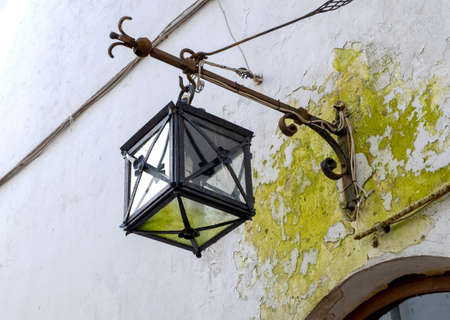 An ancient medieval lantern on an old plastered wall. Horizontal orientation, selective focus.の写真素材