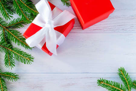 Fir twigs and gifts are laid out on a wooden surface painted blue. Christmas, New Year concept....