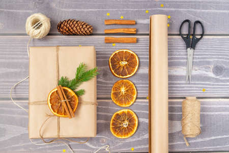 Close-up of packing a Christmas gift. Christmas decor and recyclable packaging materials. Horizontal orientation, selective focus, top view.の写真素材