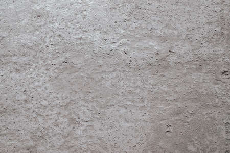 A close-up of a beige surface made of concrete, plaster, cement. Texture, background. Horizontal...