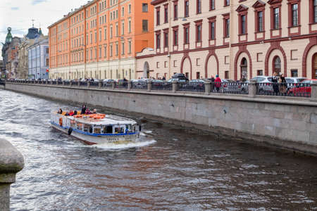 St. Petersburg, Russia - May 02, 2021. A pleasure boat sails along the Griboyedov Canal past historic buildings in the city center. Selective focus.のeditorial素材