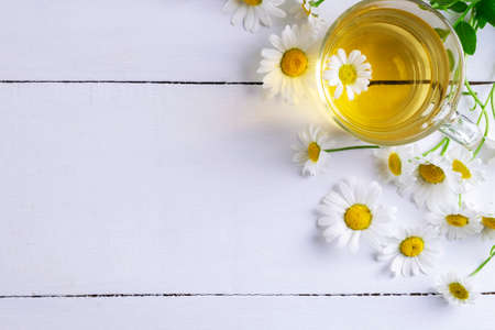 Close-up top view of a cup of chamomile tea and flowers. Alternative and traditional medicine. Herbal treatment. Selective focus. Copy space.の写真素材