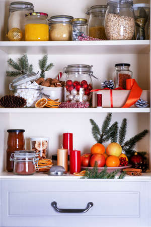Christmas concept. Preparation for holiday. Contents of kitchen cabinet with cristmas supplies and decor. Selective focus.の写真素材