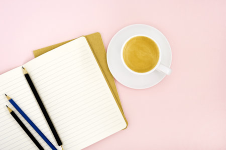 Top view mockup, two writing pads, pencils and a white porcelain cup with coffee on a pink...