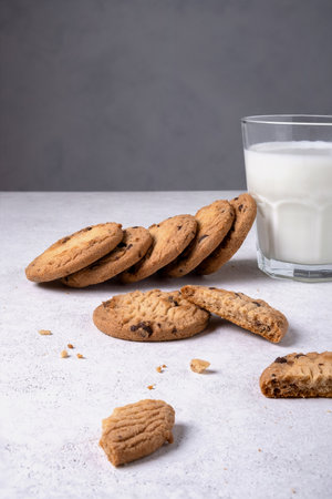 Close-up of baked oatmeal chocolate chip cookies and milk in a glass. Selective focus. Vertical...