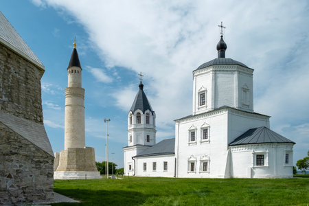 Bolgar, Tatarstan, Russia - May 24, 2023. Ancient buildings - a Muslim minaret of the 14th century and a later Orthodox church. Selective focus.のeditorial素材