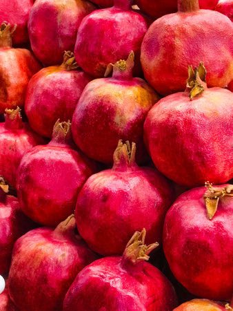 Vibrant display of fresh pomegranates stacked at a market.の写真素材