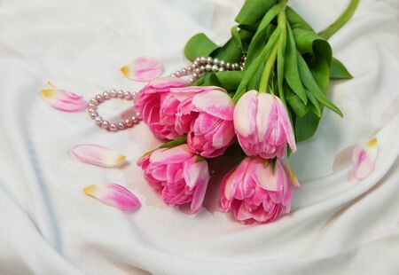 Bouquet of pink tulips and a pink pearl necklace.の写真素材