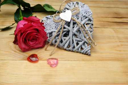 Valentine's day horizontal composition with wicker heart, glass hearts and rose, can be used for greeting cards, posters, placards, covers, etc.の写真素材