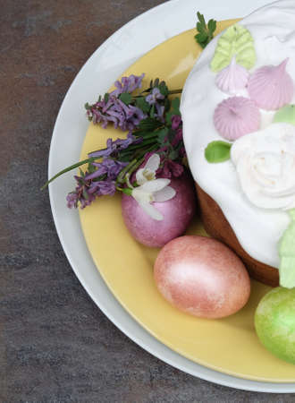 Multi-colored Easter eggs on a plate with Easter cake, macro photo, composition detail, top view, selective focus.の写真素材