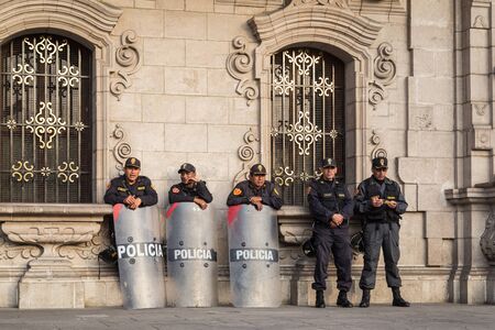 Lima, Peru - September 05, 2015: Five policemen are guarding the central square in front of the government palace on a Saturday afternoon.のeditorial素材