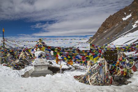 Photograph of signs and prayer flags on Thorung La Pass on the Annapurna Circuitの写真素材