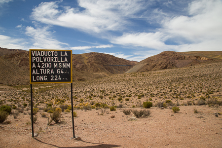 Photograph of an information sign about the Polvorilla viaduct sign and train driving in the background.の写真素材