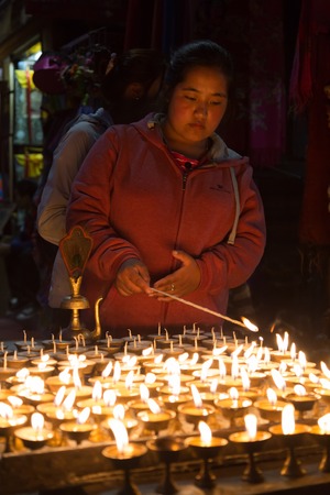 Kathmandu, Nepal - December 06, 2014: Pilgrims at Boudhanath stupa lighting up butter candles for full moon festival.のeditorial素材